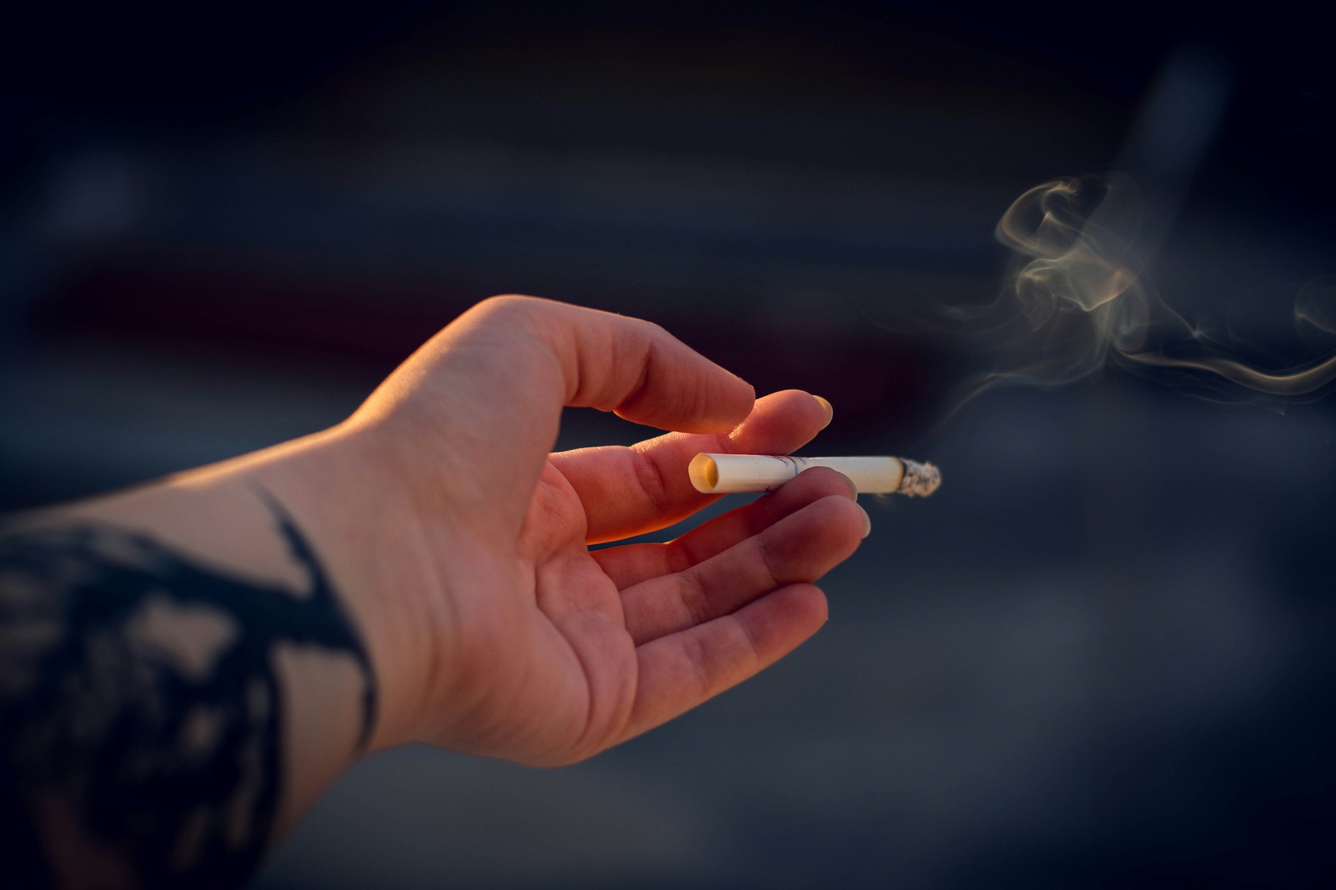 Zlomená cigareta medzi rukami ako symbol odvykania od fajčenia